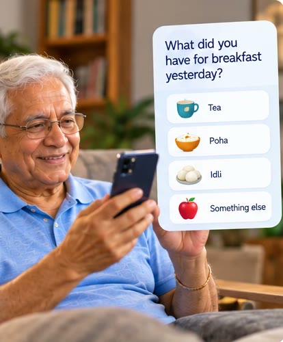 A smiling elderly Indian man at home looking at his phone.